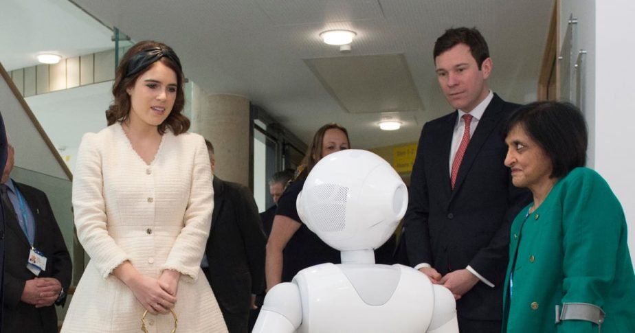 Prince Andrew, Princess Eugenie, and Jack Brooksbank were enthralled to meet the new hospital resident robot, Pepper, who bring smiles to the patients' faces and cater to their needs.
