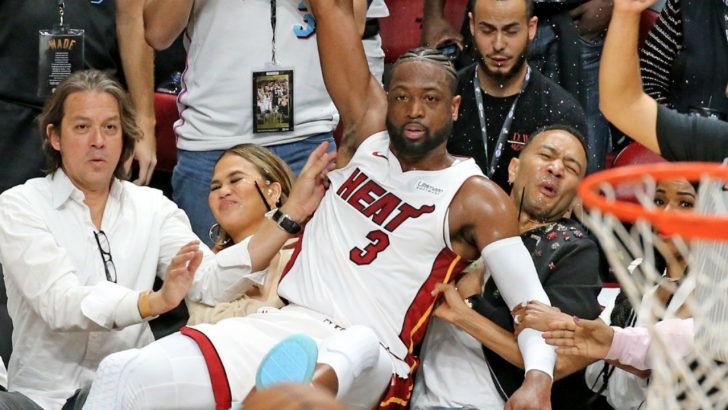 Legend and Teigen couldn't help but laugh as they shared photos of Dwayne Wade crashing on their seats while grabbing the ball on their Twitter accounts.
